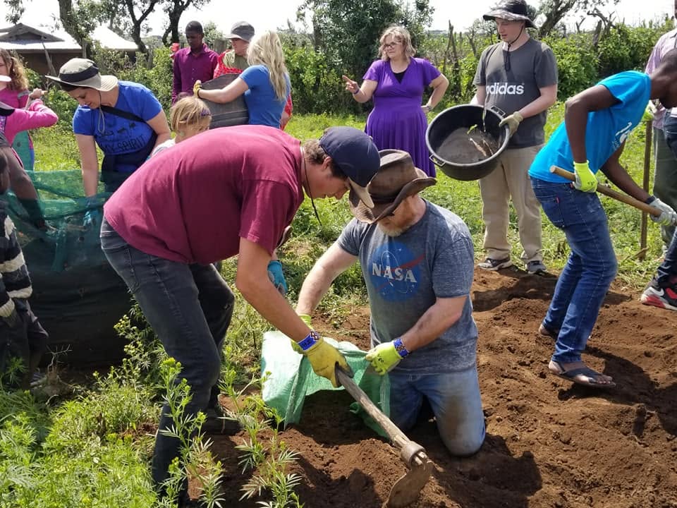 Volunteers and Kenyan community members building a Garden Tower together