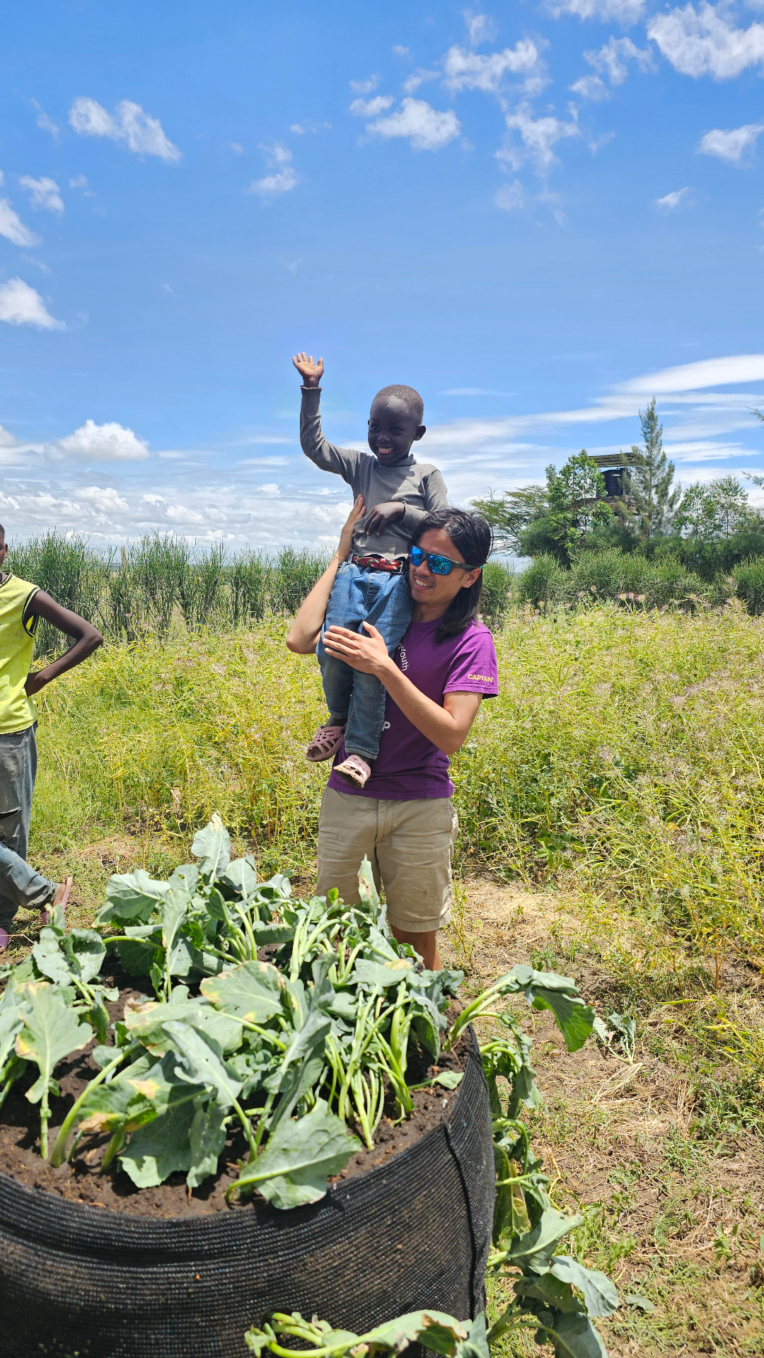 Chris Dabao lifting a child near a Garden Tower