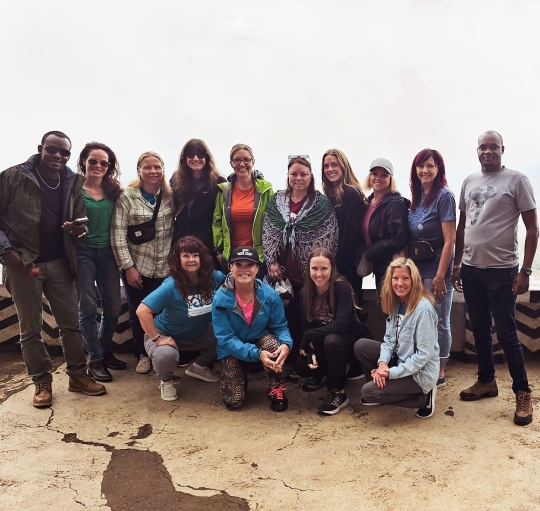 An expedition team standing alongside Maasai community members in Kenya